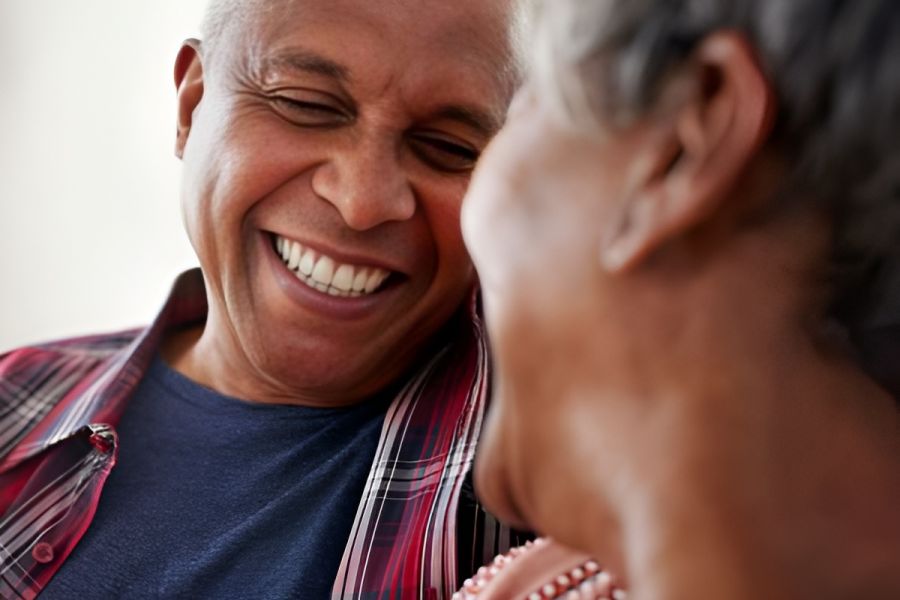 Acclaim at Cary Pointe apartment homes with An older couple smiling and laughing together, one holding a white mug.