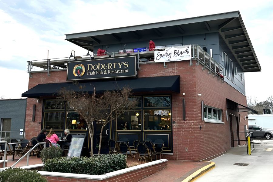 Acclaim at Cary Pointe apartment homes with Exterior of Doherty's Irish Pub & Restaurant with outdoor seating and people dining.
